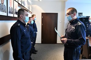 Komendant Wojewódzki Policji wrecza rozkazy policjantom.