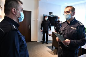 Komendant Wojewódzki Policji wrecza rozkazy policjantom.