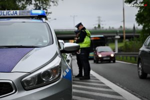 Na zdjęciu widoczny policjant wydziału ruchu drogowego w trakcie kontroli drogowej.