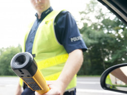 zdjęcie poglądowe przedstawiające policjanta z alkotestem w trakcie badania kierowcy
