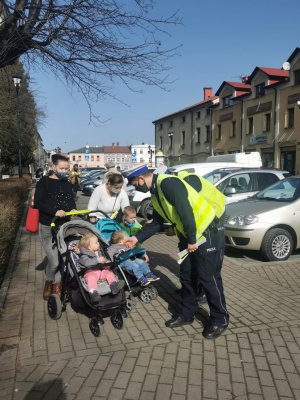 policjanci wręczają odblask kobietą, które jadą z wózkami z dziecmi