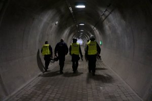 policjanci idący tyłem w śluzie bocznej tunelu