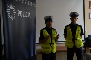 policjantka i policjant stoją na środku sali obok baner śląskiej policji