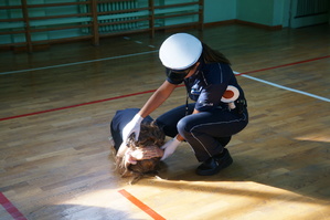 policjantka wykonuje ćwiczenie praktyczne z uczniem