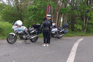 zdjęcie kolorowe policjant motocyklista kontroluje motocyklistę