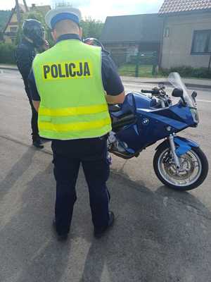 zdjęcie kolorowe policjant w czasie kontroli motocyklisty