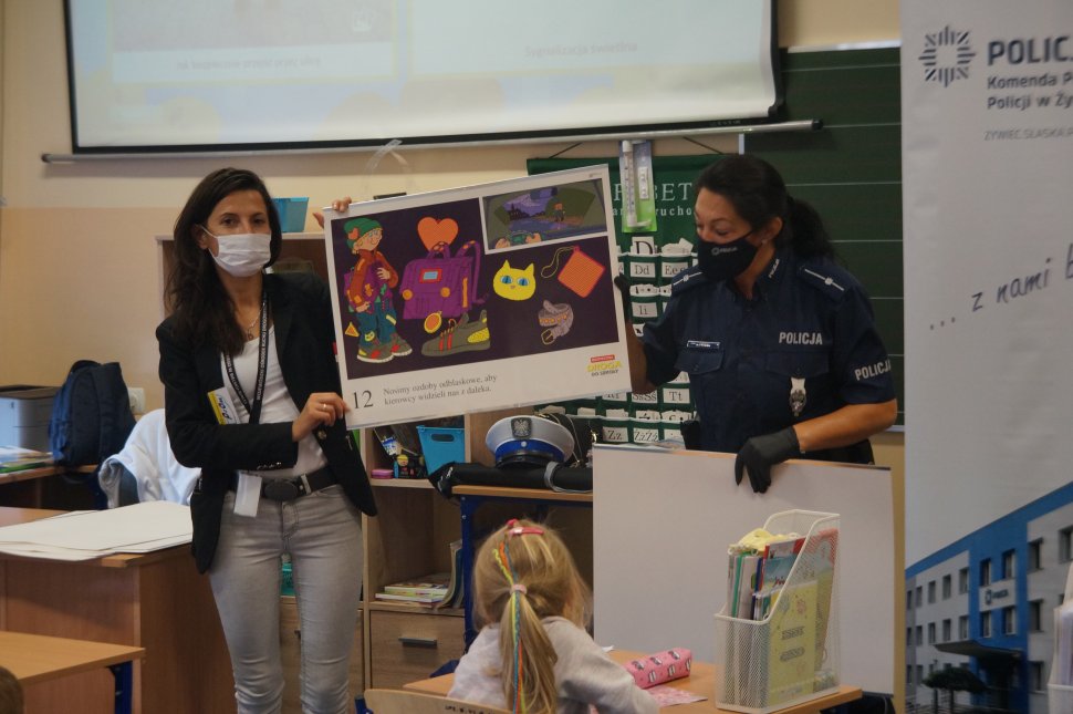 policjantka i przedstawiciel word trzymają planszę edukacyjną