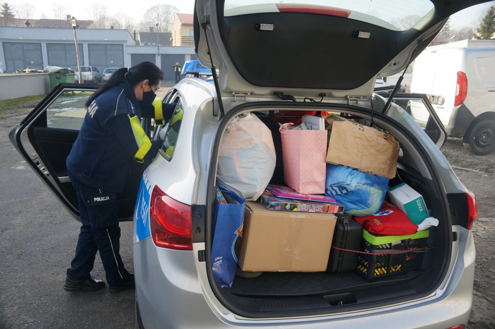 policjantka obok radiowozu w którym są zabawki