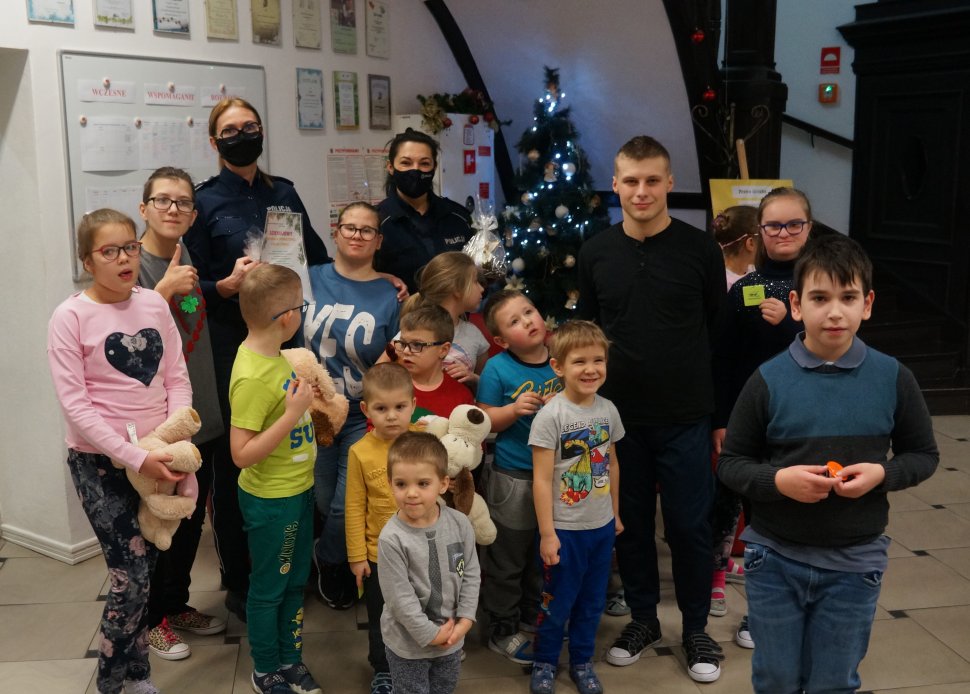 zdjęcie grupowe stoją policjantki obok dzieci w tle choinka