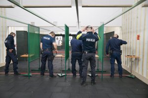 czterech policjantów przygotowuje się do strzelania pod okiem instruktora