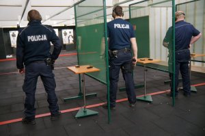 trzech policjantów przygotowuje się do strzelania
