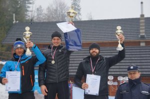 mężżczyźni z pucharami na podium