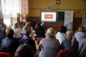 Policjantka i uczestnicy w sali w czasie prezentacji