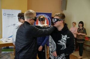 czterech uczniów z alkogooglami wykonuje zadanie przywitania się