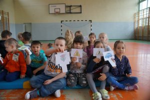 uczniowie pokazują narysowane znaki drogowe