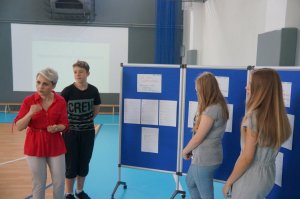 pedagog szkolny oraz trzech reprezentantów grup przy przygotowanych tablicach