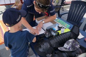 policjanci w czasie pobierania odcisków palców