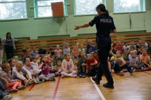 policjantka w czasie prelekcji przodem siedzą dzieci