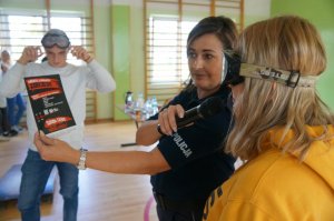 dziewczyna w założonych alkogooglach próbuje przeczytać tekst