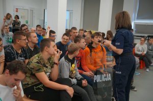 policjantka w czasie prelekcji przekazuje uczniowi telefon aby udzieliłodpowiedzi
