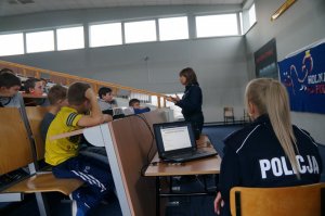 policjantka w czasie prelekcji druga siedzi tyłem w tle dzieci