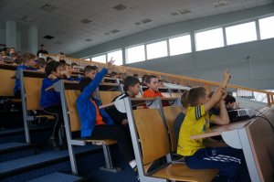 uczniowie siedzą bokiem, część z nich się zgłasza