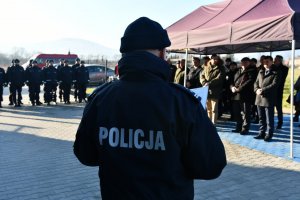 przemówienie komendanta powiatowego policji w Żywcu, komendant stoi tyłem w tle zaproszeni goście