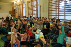policjantka siedzi wśród uczniów wszyscy trzymają ulotki