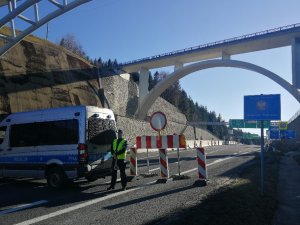 policjant stoi obok radiowóz w tle granica państwa