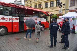 policjanci stoją przed ambulansem