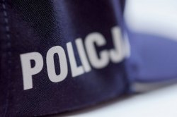 fragment policyjnej czapki z napisem policja