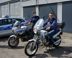 chłopak siedzi na policyjnym motocyklu obok stoi motocykl, policjantka i radiowóz