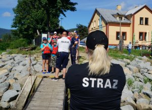 strażak stoi tyłem w tle policjant stoi tyłem i dzieci