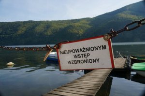 jezioro w tle góry tabliczka z napisem nieupoważnionym wstęp wzbroniony