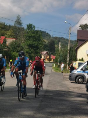 peleton rowerzystów z boku policyjne radiowozy