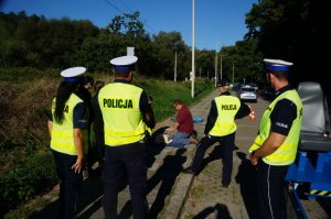 osoby ćwiczą pierwszą pomoc obok policjanci