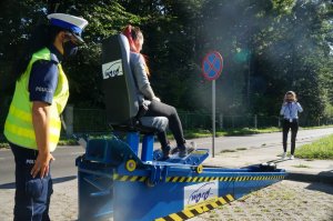 dziewczyna na symulatorze zderzeń obok policjantka