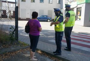 policjanci wręczają kobiecie odblask