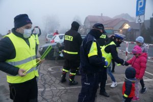 policjanci i strażacy wręczają odblaski