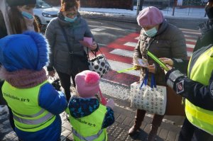 przedszkolaki i policjantka wręczają laurki seniorom