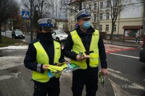 policjnaci z elementami odblaskowymi w tle ulica