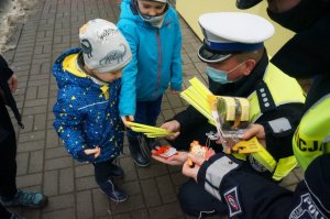 policjanci wręczają odblaski dzieciom