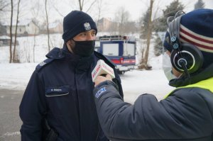 policjant w czssie nagrania do radia redaktor stoi tyłem