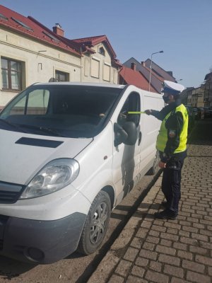 policjant wręcza odblaski kierowcy