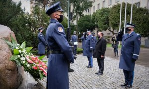 policjanci stoją przy pomniku obok poczet