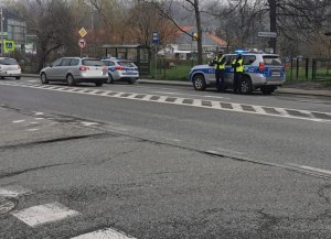 policjanci st6oją obok radiowozu w tle ulica