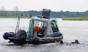 Zdjęcie policyjnej motorówki nad pływającej po jeziorze