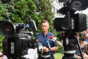 na pierwszym planie kamery w tle policjant uidzielającywywiadu