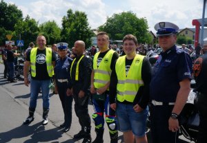 stoją obok siebie motocykliści i policjanci w tle motocykle