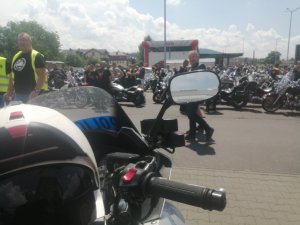 fragment policyjnego motocykle w tle inne zaparkowane motocykle i motocykliści